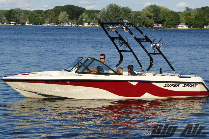 red and white boat on water with black Cuda wakeboard tower