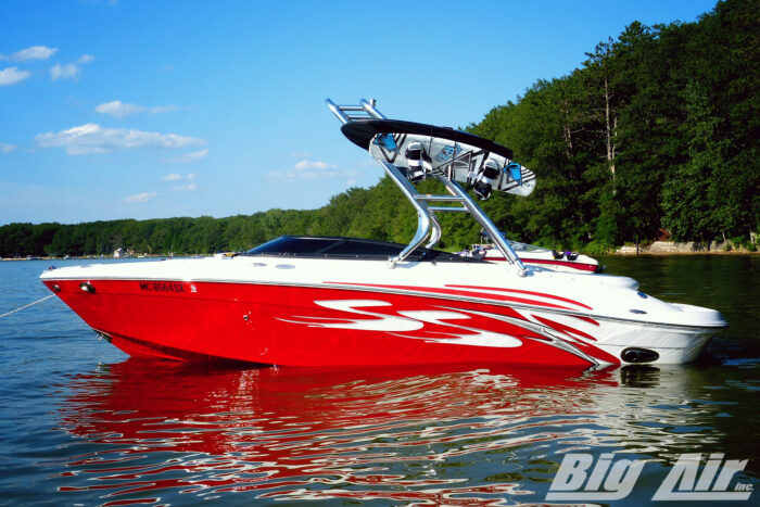 Red and white boat on water with Cuda tower