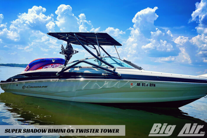 boat sitting on the lake with a tube resting on the back of the boat. Showing the Big Air Twister tower and Super Shadow Bimini.