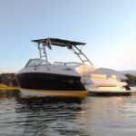 navy blue and white boat on the water with a big air cuda tower, big air super shadow, and a big air flag holder mounted onto the boat