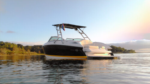 navy blue and white boat on the water with a big air cuda tower, big air super shadow, and a big air flag holder mounted onto the boat