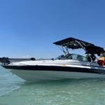 White boat with a blue stripe showcasing the Big Air Cuda Tower and Tube Top Bimini