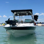 Front view of a white boat with a blue stripe showcasing the Big Air Cuda Tower and Tube Top Bimini