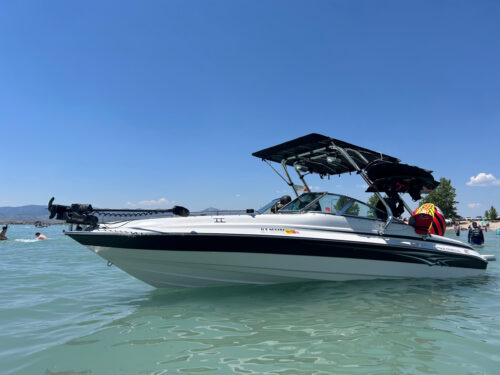 White boat with a blue stripe showcasing the Big Air Cuda Tower and Tube Top Bimini