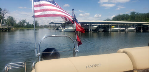 customer testimonial photo showing the American Flag waving in the Big Air Flag Holder mounted on a pontoon tower