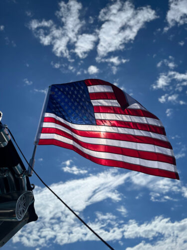 close up image of the american flag waving on top of a boat tower