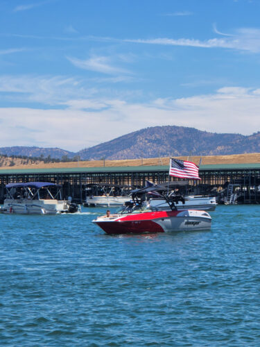 A red and white Sanger boat on the water with an American Flag