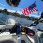 2017 Yamaha 212 Limited boat on the water with clear blue skies showing an American flag mounted on the boat tower