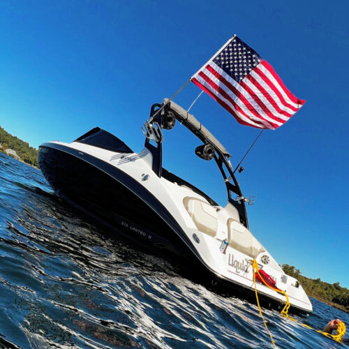 2017 Yamaha 212 Limited boat on the water with clear blue skies showing an American flag mounted on the boat tower