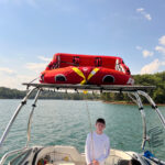 A front view image of a boat showing a big air vapor tower and tube top bimini