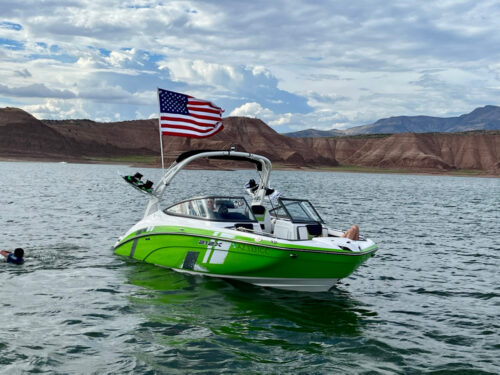 Bright green and white Yamaha boat with an american flag waving in the wind