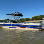 White and blue Malibu boat showcasing the Big Air Cuda tower mounted by the bow and sweeping towards the stern. The tower has the Big Air Collapsible Bimini mounted onto it too.