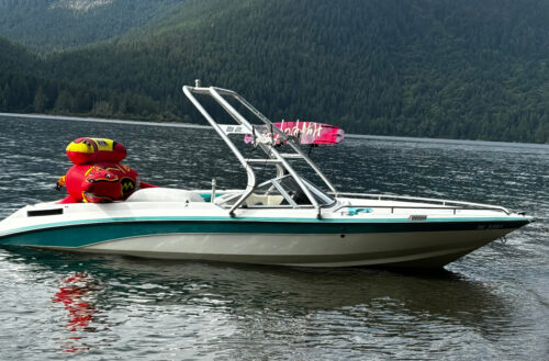 A white boat with teal stripes showcasing the Big Air Cuda tower in the polished finish. Mounted at the bow, sweeping to the stern.