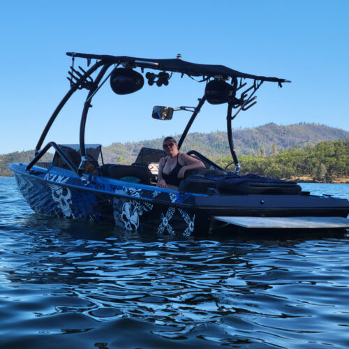 tri-hull boat on the water showing the big air vapor tower and super shadow bimini mounted on it