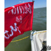 Red Flag with white text saying "Chillin the Most" mounted at the back of a boat, going across the water.
